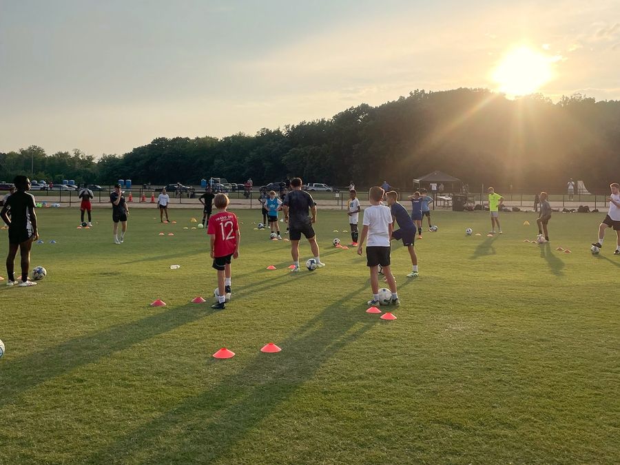 A Core IDP evening training session on a turf field at sunset